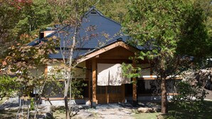 A traditional Japanese-style building with a wooden facade, a tiled roof, and a stone pathway leading to the entrance. - Miyama Sanso (Minamioguni)