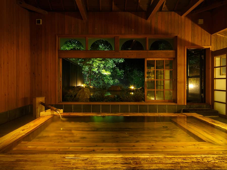 Un interior de madera tradicional con un ventanal grande que da a un jardín.