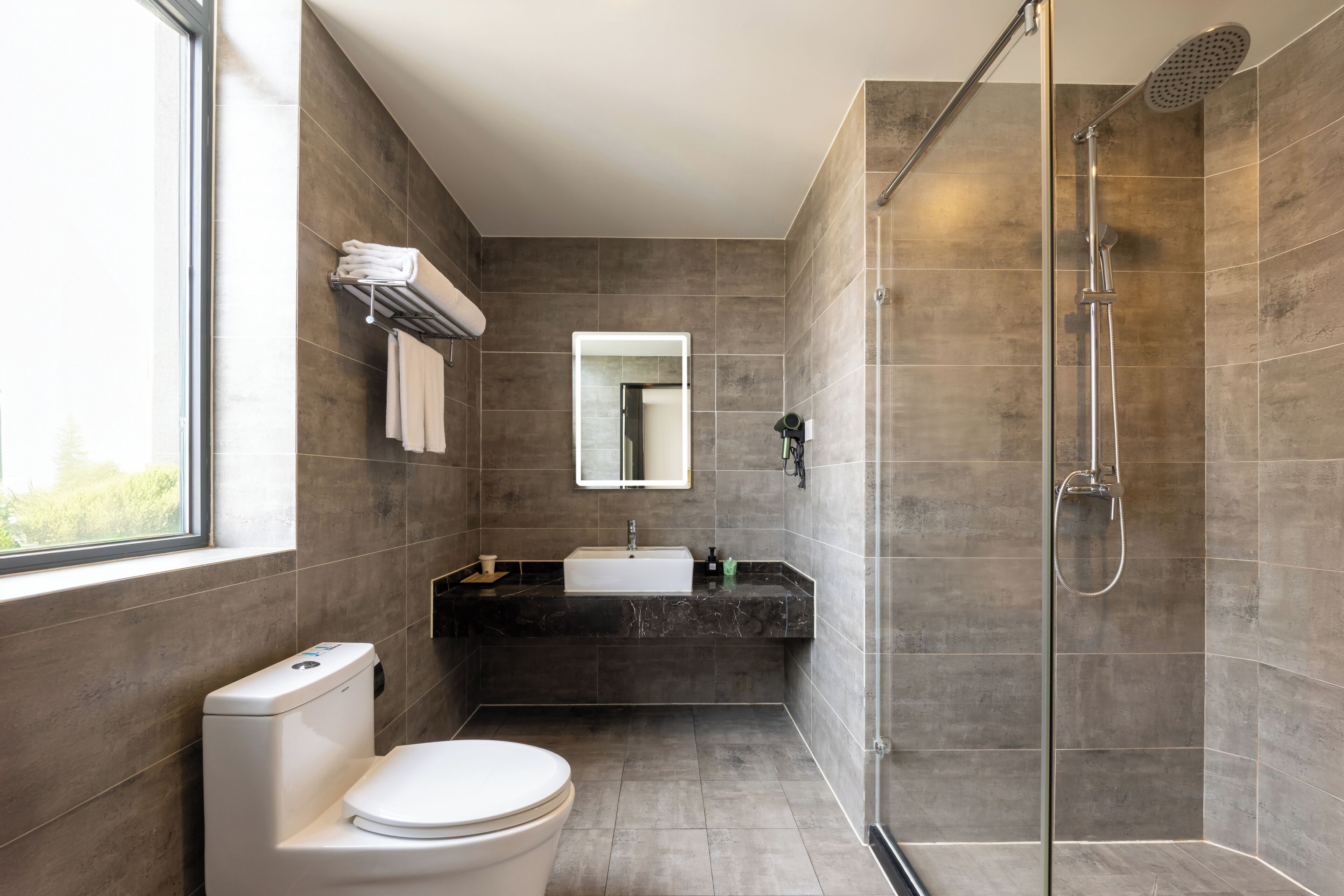 Une salle de bain moderne équipée de toilettes, d’un lavabo et d’une douche.