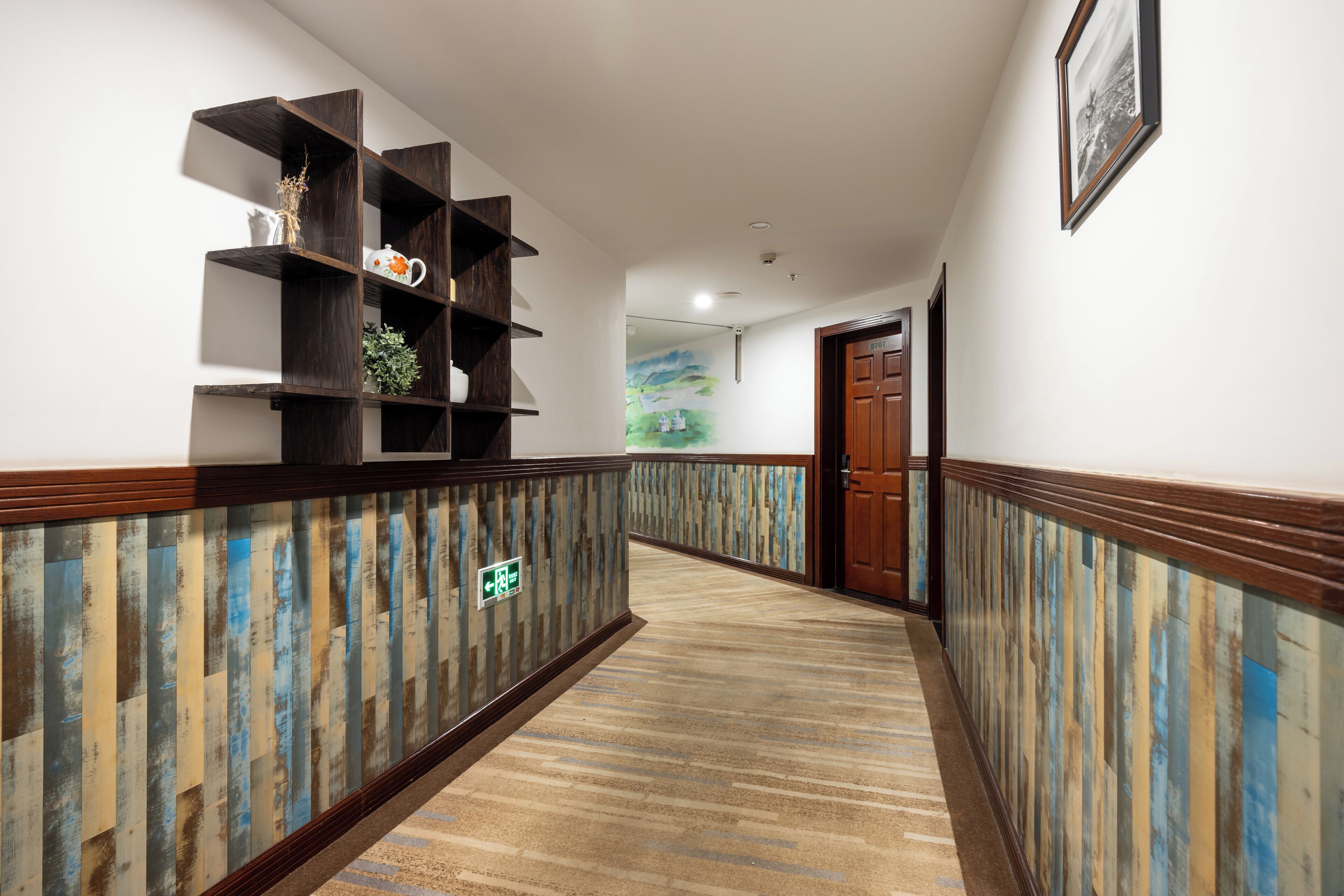 A hallway with wooden paneling, a reception desk, and a door.