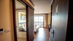 A hotel room with a bed, a nightstand, a lamp, and a window with curtains. - The LD Pattaya (Pattaya)