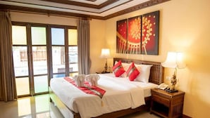 A hotel room with a large bed, two bedside lamps, a telephone, and a painting on the wall. - The LD Pattaya (Pattaya)