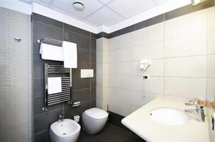 Un bagno moderno con un lavandino ampio, due servizi igienici e un portasciugamani.