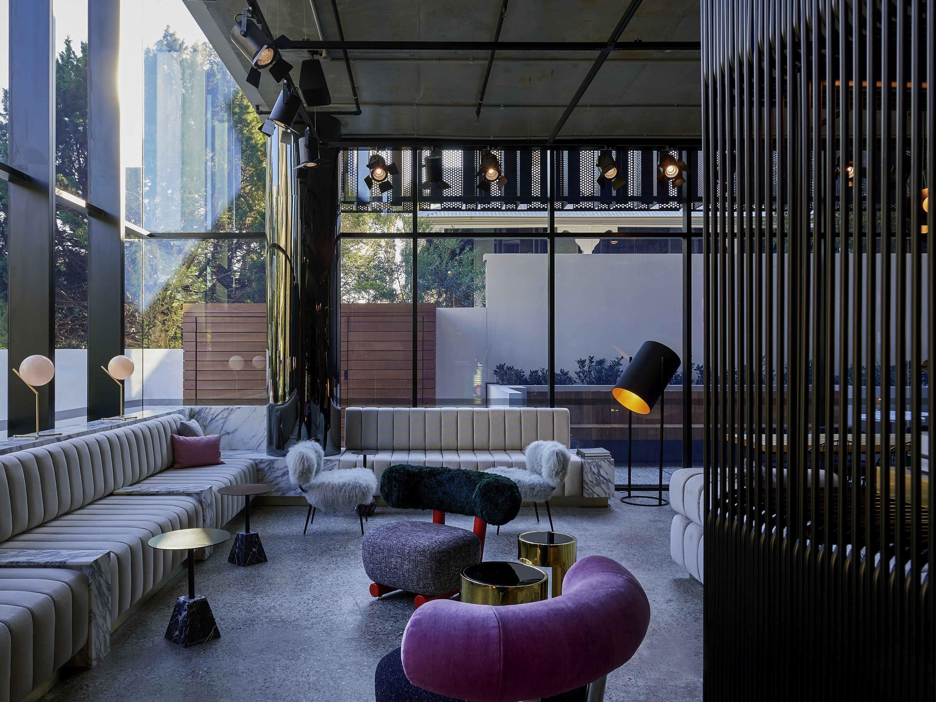 Uma sala de estar moderna com sofá, pufê e abajur.