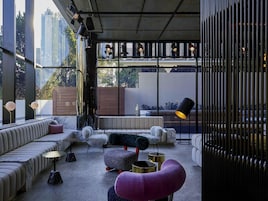 A modern living room with a sofa, ottoman, and floor lamp.