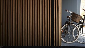 A wooden slat wall with a bicycle leaning against it. - Tribe Perth Kings Park (West Perth)