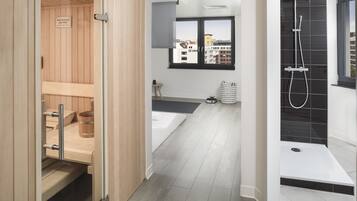 Relax in a serene bathroom with a sauna, city view, and separate shower area.