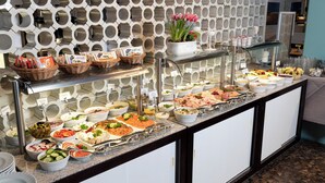 A buffet with various food items and a decorative wall with circular patterns.