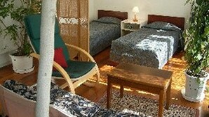 A cozy room with a bed, a chair, a table, and a potted plant. - St village (Hokuto)