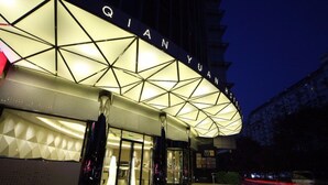 Ein Hotel mit modernem, geometrischem Fassadengestalt und beleuchteter Beschilderung.