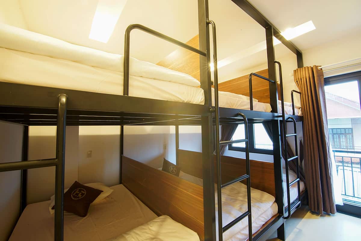 Un dormitorio con literas, ventana y cortinas.