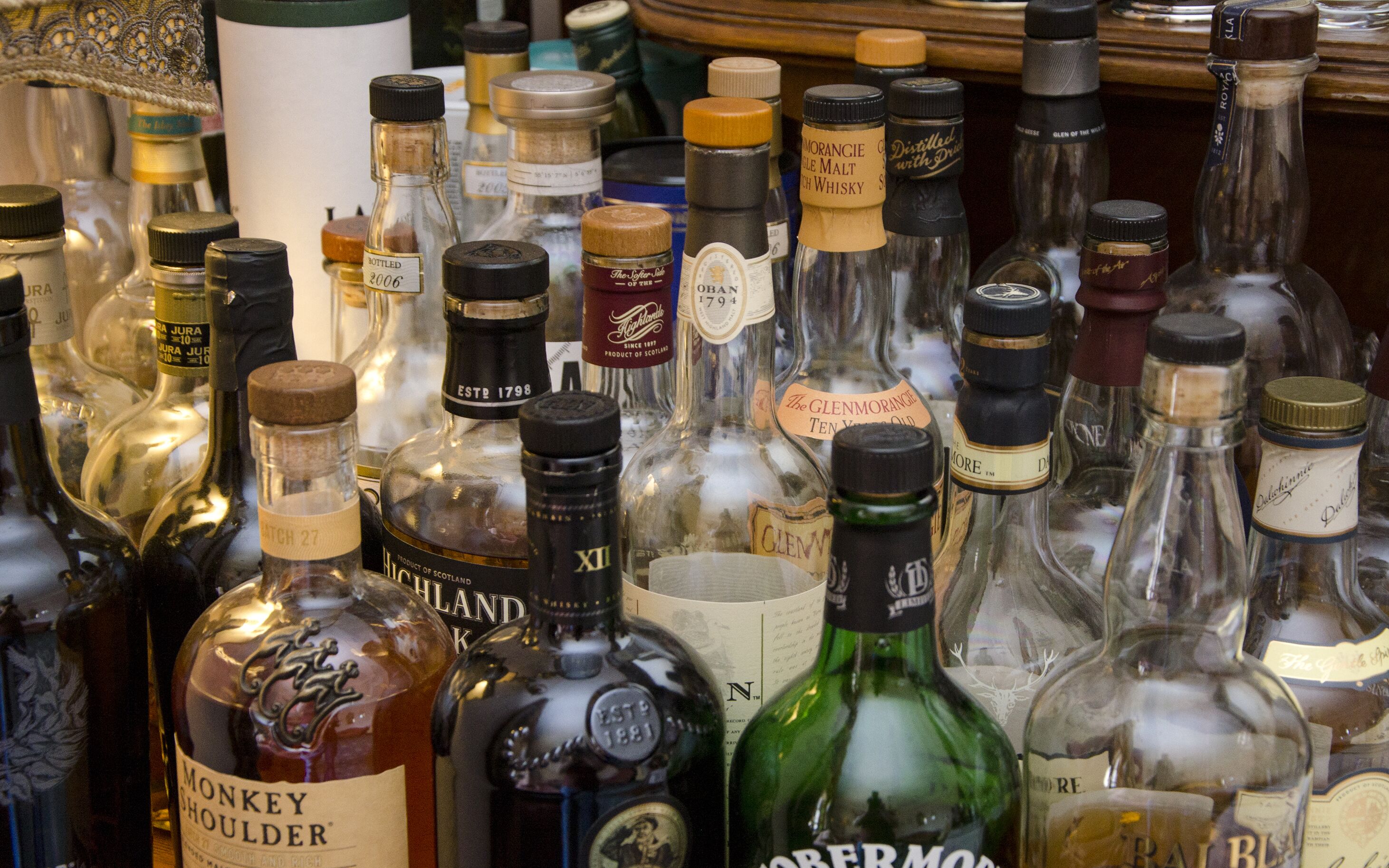 A variety of bottles, likely containing alcoholic beverages, displayed closely together.