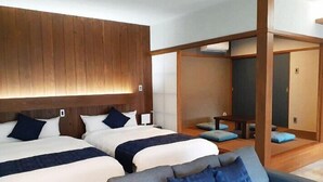 A hotel room with two beds, a sofa, and a wooden partition. - Churamui Terrace (Motobu)
