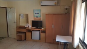 Cozy room with a kitchenette, television, and ample storage space.