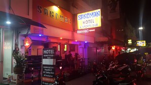 A hotel with a sign reading "SANDMAN HOTEL & SPORTS BAR" and a sign for "HOTEL 1000 rooms for rent." - Sandman hotel and Sports bar (Pattaya)
