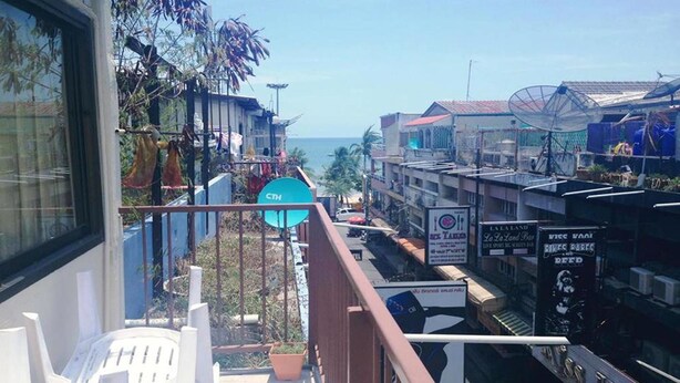 A balcony with a view of a coastal street, a satellite dish, and a sign for 'La Laand'. - Sandman hotel and Sports bar (Pattaya)