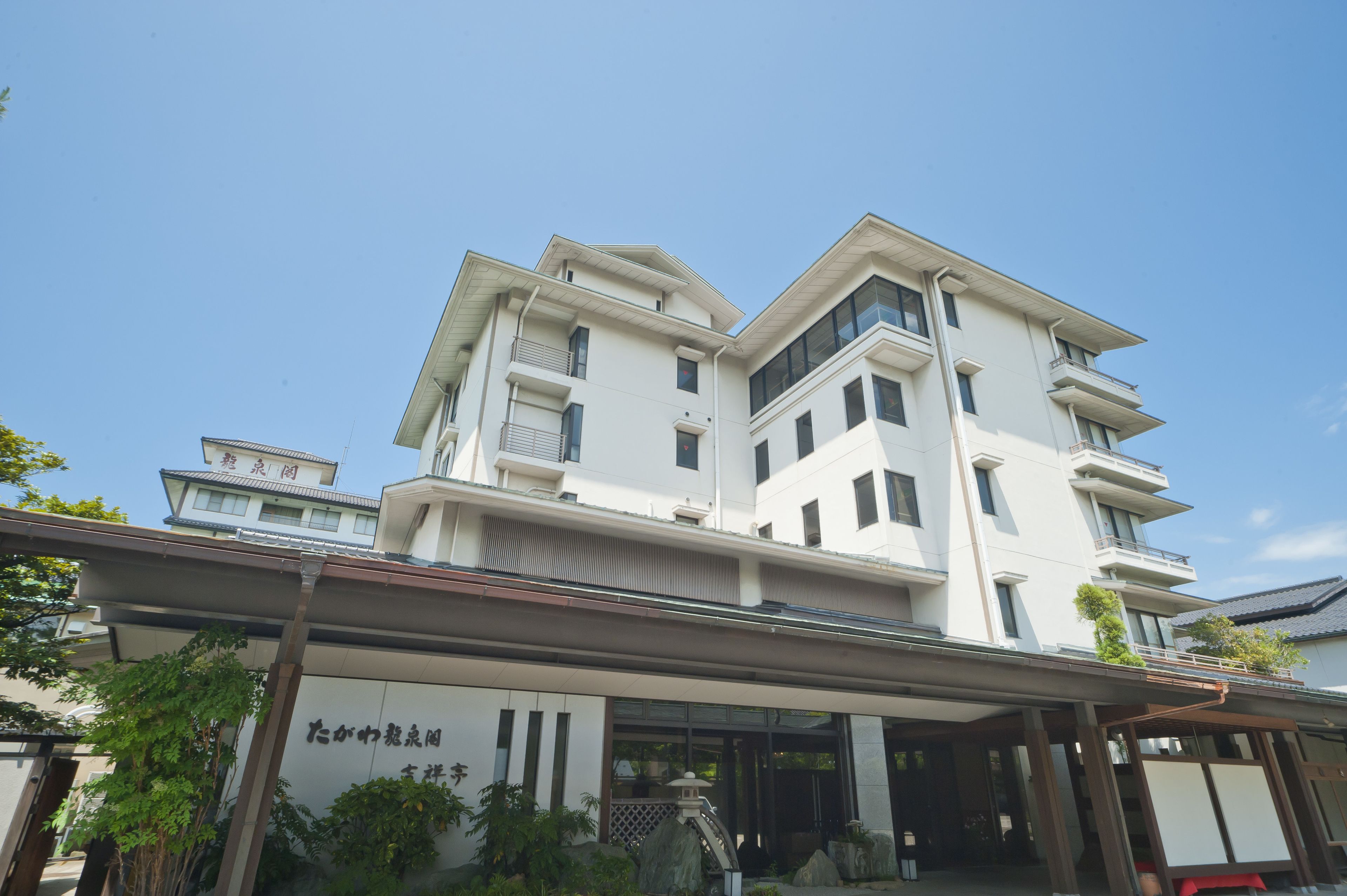 A multi-story building with a modern architectural design, featuring balconies and large windows.