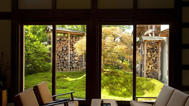 Una habitación japonesa tradicional con suelo de tatami, una mesa baja y un sofá.