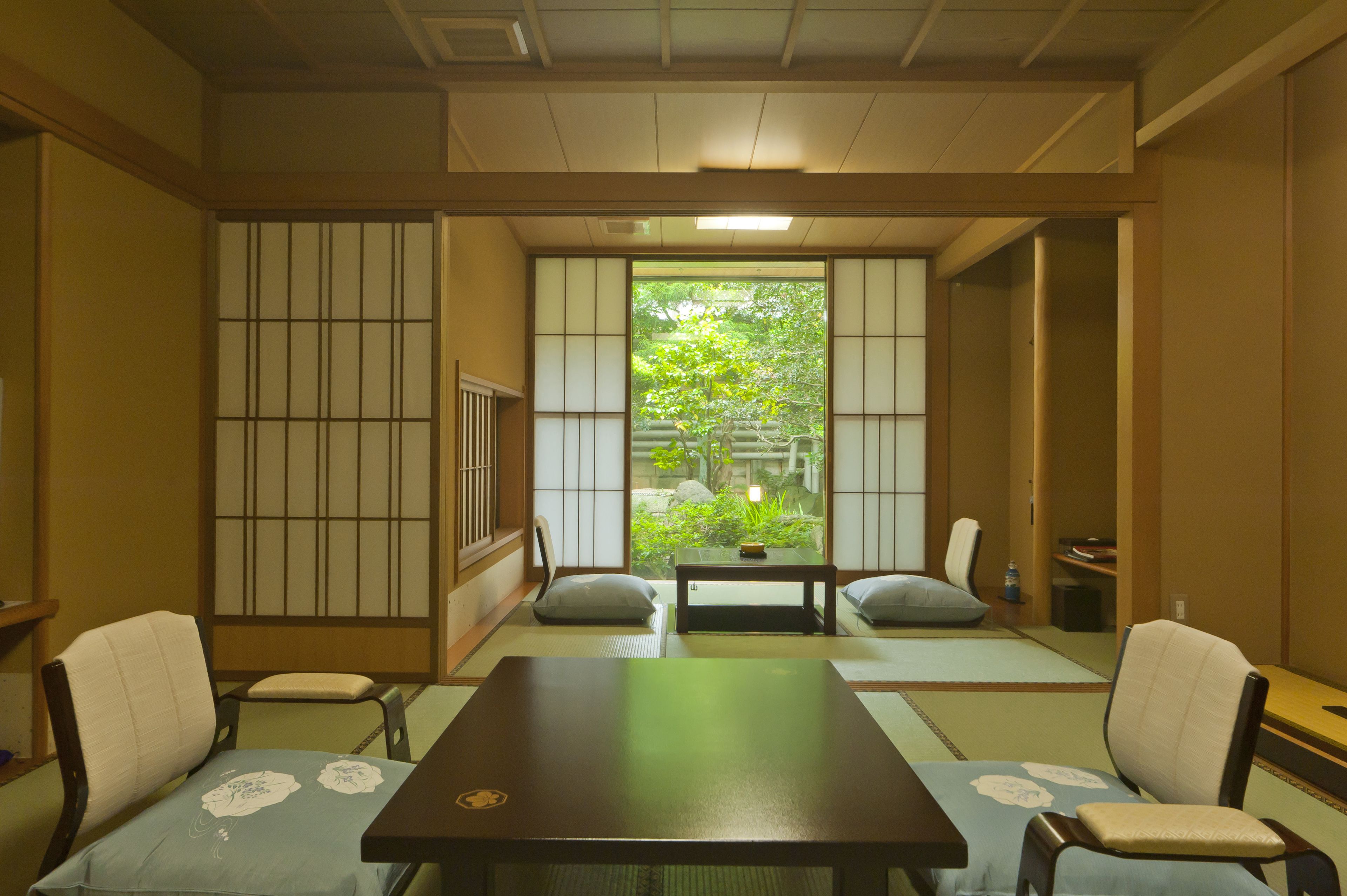 A traditional Japanese room with tatami flooring, a low table, and shoji screens.