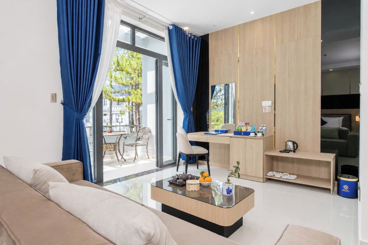 A modern living room with a sofa, a coffee table, and a dining area with a chair and table.