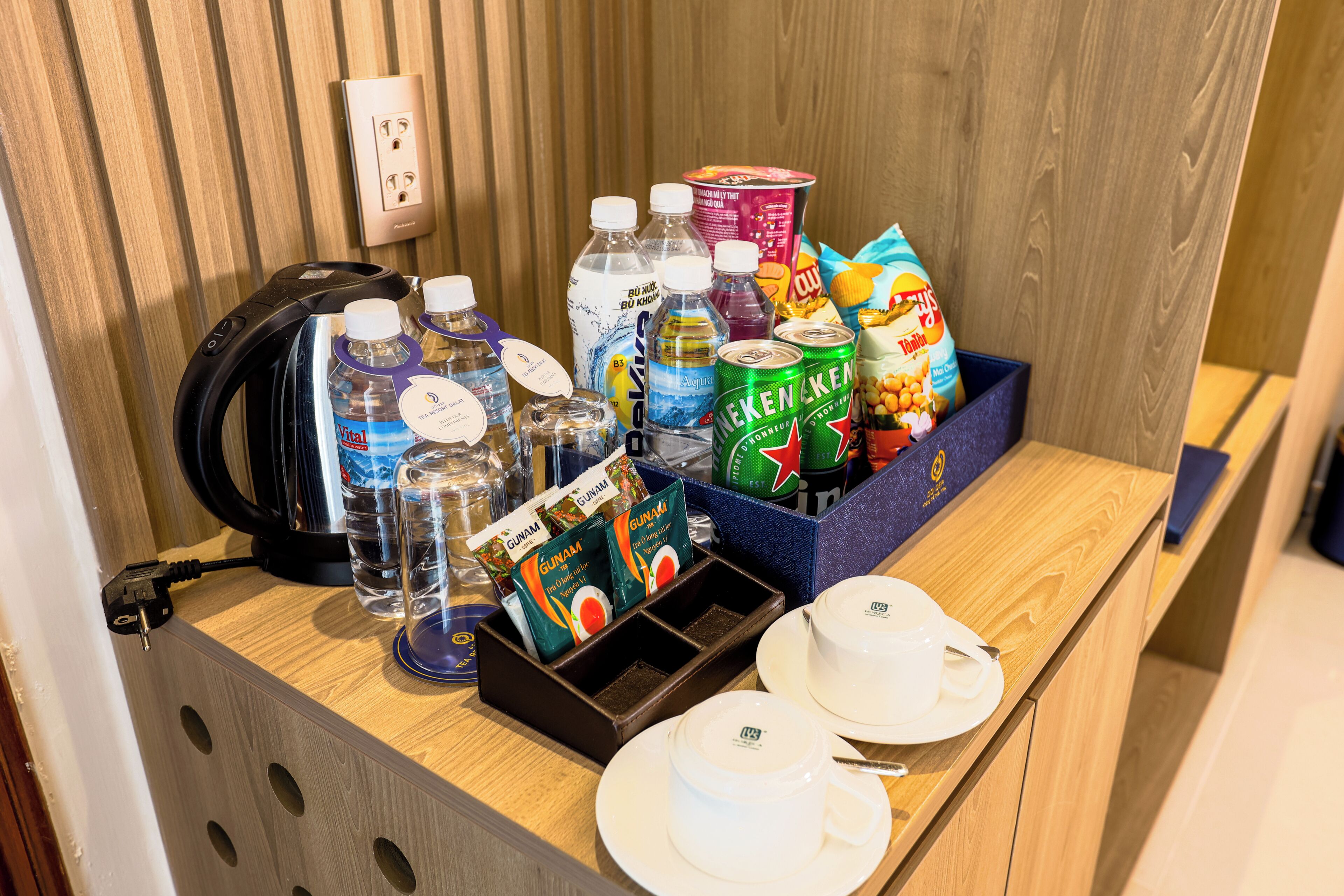 A breakfast bar with various beverages, snacks, and a kettle.
