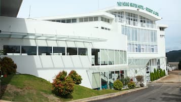 Experience the THU THY HOANG NGUYEN HOTEL's sleek design, featuring a curved roofline and expansive glass windows.