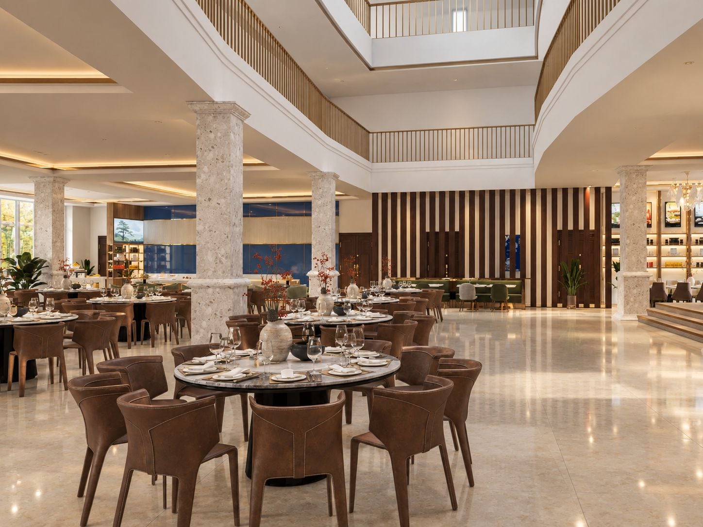 Un hall d’hôtel spacieux, doté de nombreuses tables, de sièges confortables et d’un plafond haut avec une verrière.