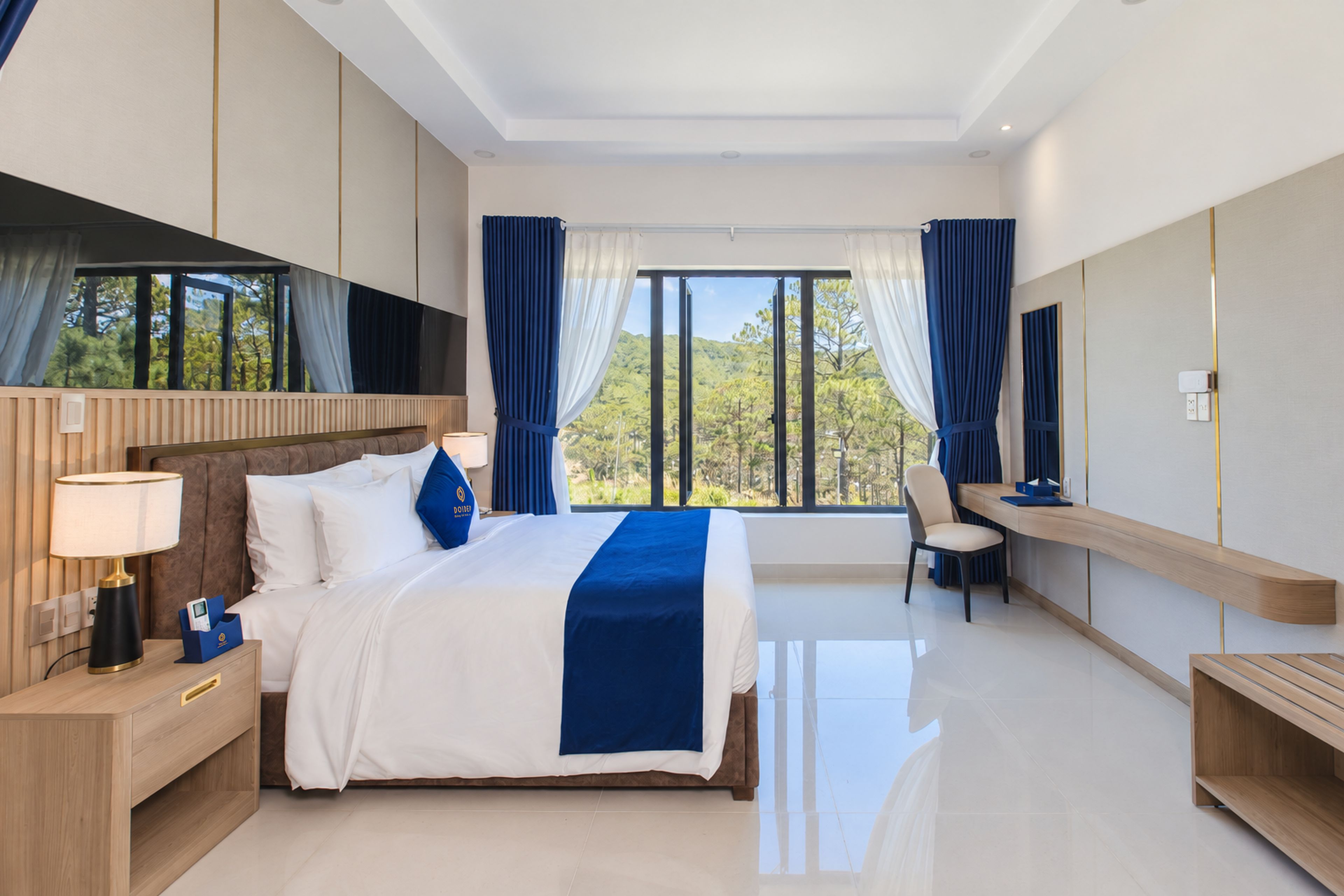 Habitación de hotel moderna con una cama grande, un escritorio y vistas al exterior.