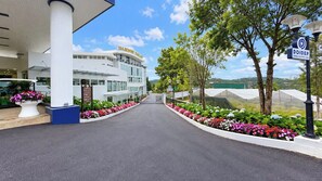 A modern building with a sign reading 'TEA RESORT DALAT' and a pathway lined with colorful flowers leading to it. - Tea Resort Dalat (Lac Duong)