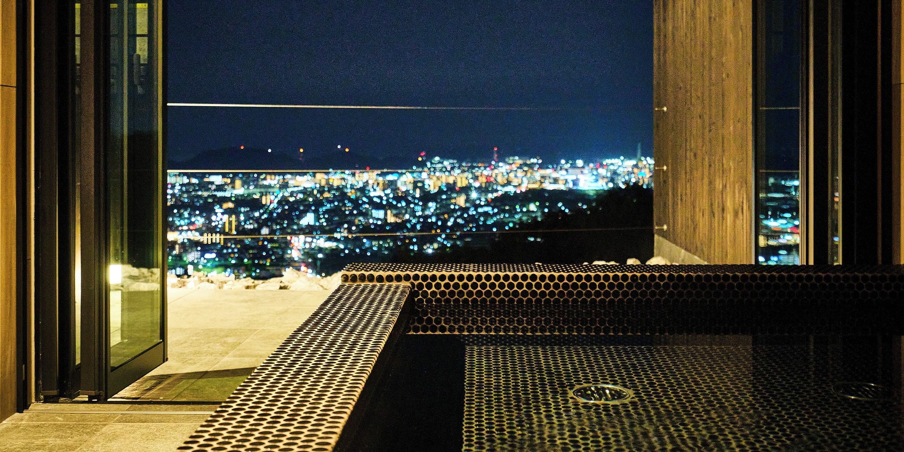 A view from a balcony overlooking a cityscape at night.