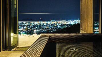 A view from a balcony overlooking a cityscape at night.