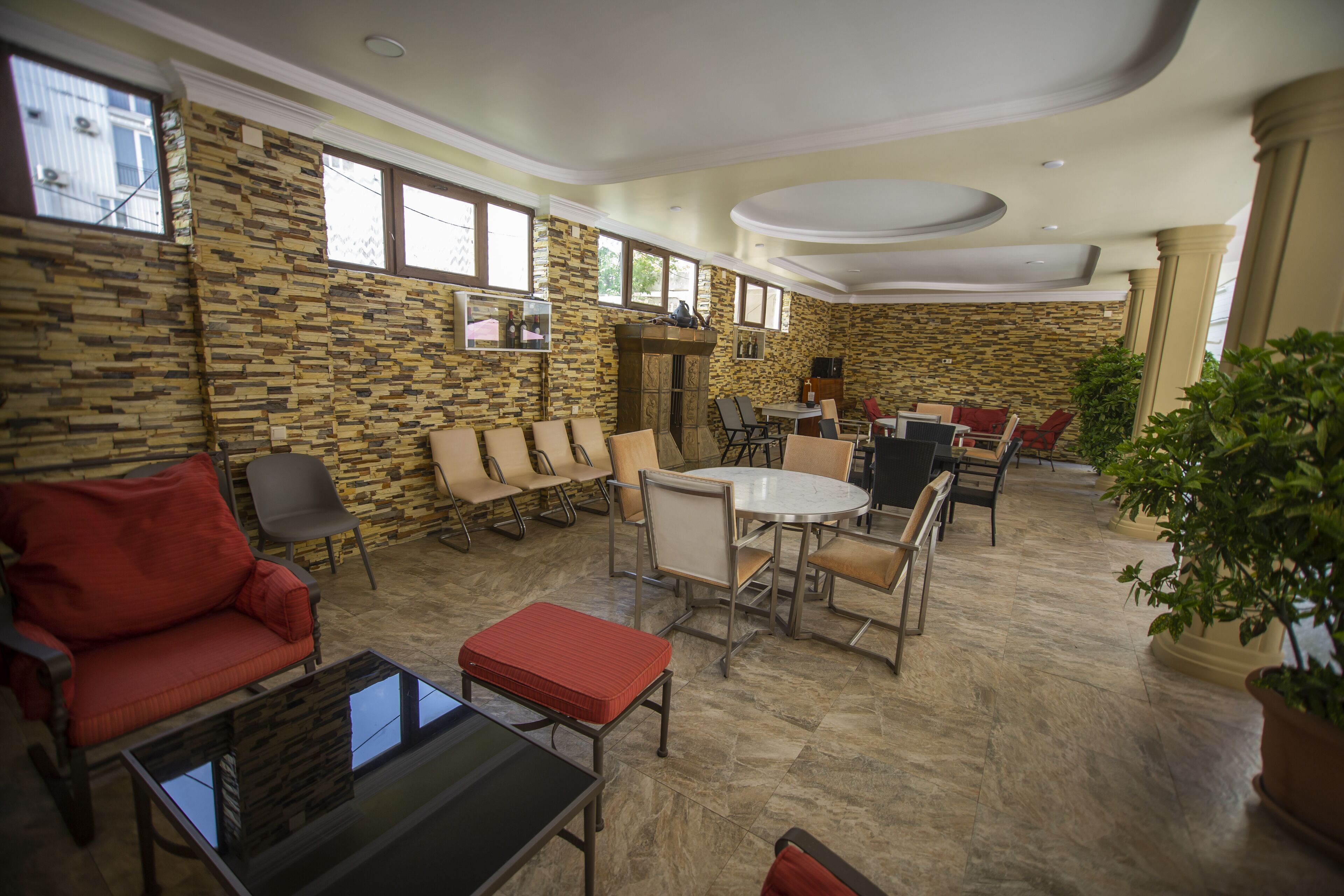 A spacious living area with a stone wall, a round dining table, and multiple seating options including a sofa and chairs.