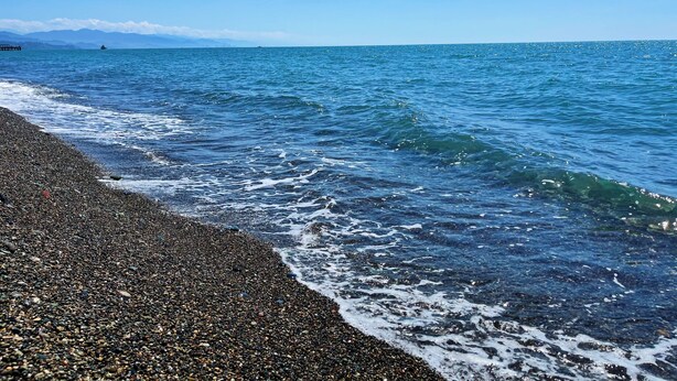 Une plage de galets où les vagues viennent se briser sur le rivage.
