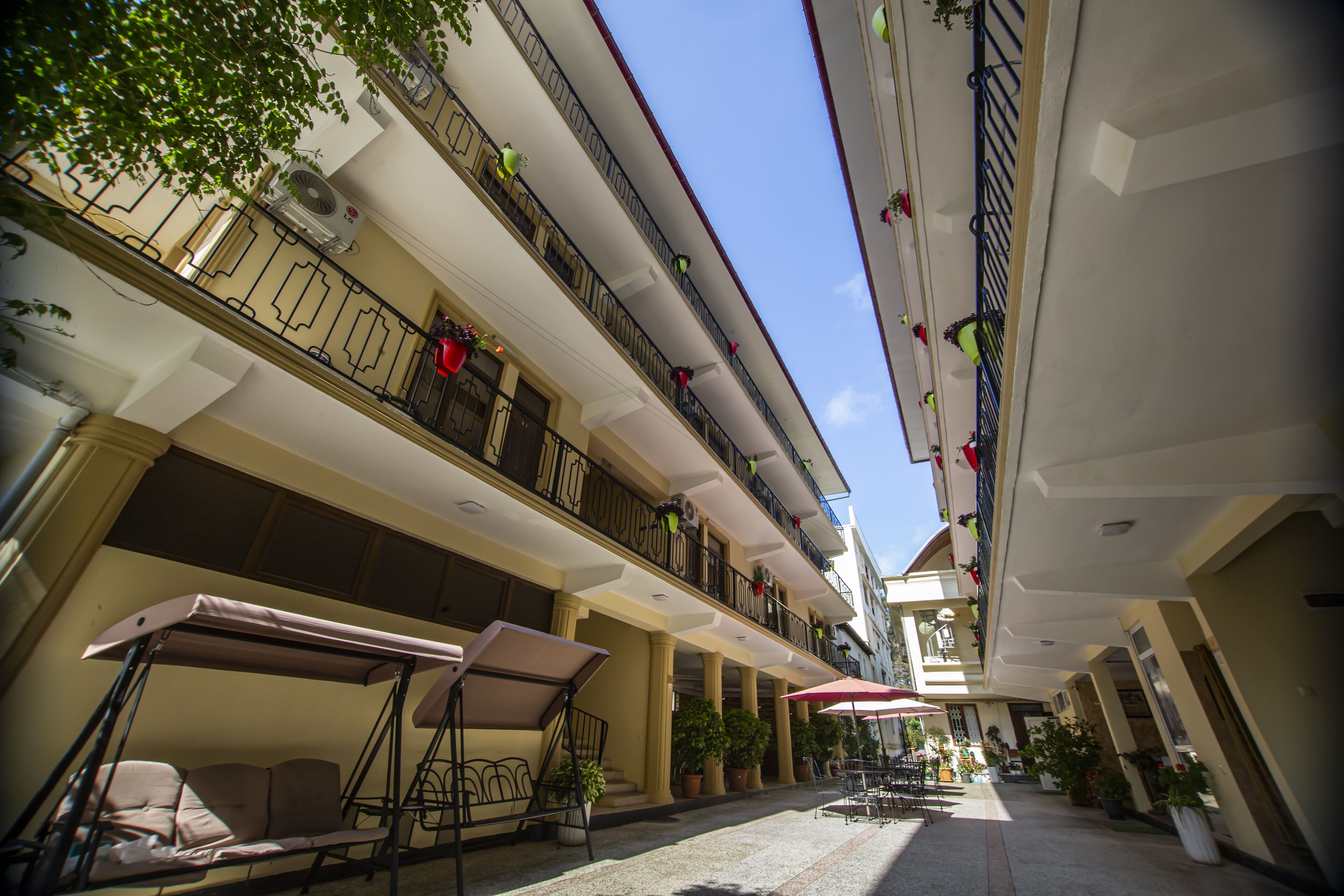 A multi-level outdoor terrace with seating areas, potted plants, and balconies.