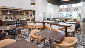 A modern restaurant with a central island, high ceilings, and pendant lighting. - Homewood Suites by Hilton San Jose Santa Clara (San Jose)