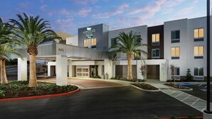 A modern hotel with a central entrance, palm trees, and a clear sky. - Homewood Suites by Hilton San Jose Santa Clara (San Jose)