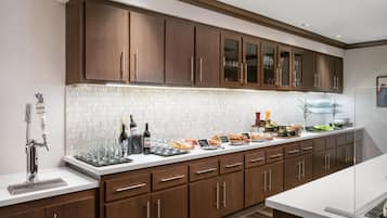 Una cocina moderna con armarios de madera oscura, un salpicadero de azulejos blancos y una barra desayunadora.