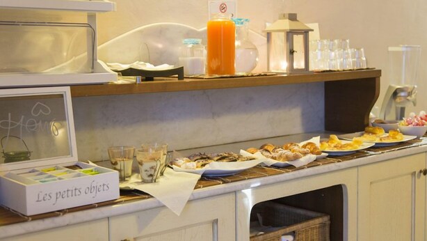 A breakfast buffet with various pastries, a juice dispenser, and a sign reading "Les petits objets". - Florence Decamerone B&B (Florence)
