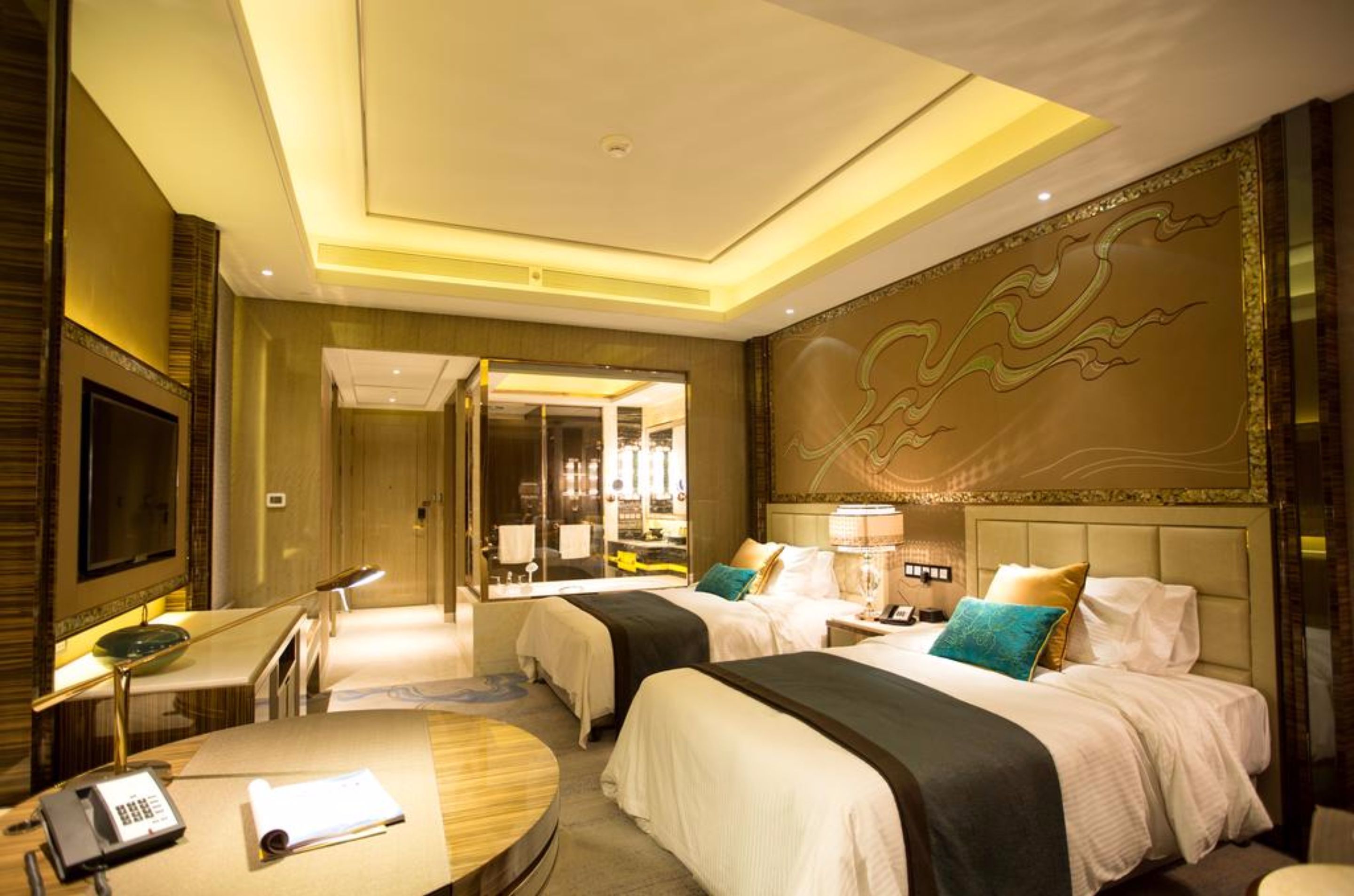 Ein Hotelzimmer mit zwei Betten, einem Schreibtisch mit Telefon und einer großen Wandmalerei.