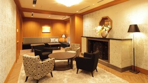 A hotel lobby with a fireplace, seating area, and a large mirror. - Hiyori Hotel Maihama (Urayasu)