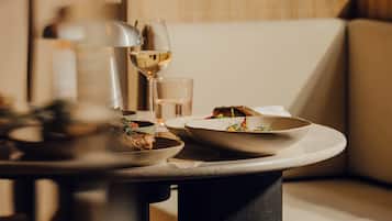 Una mesa con platos de comida, una copa de vino y una vela.
