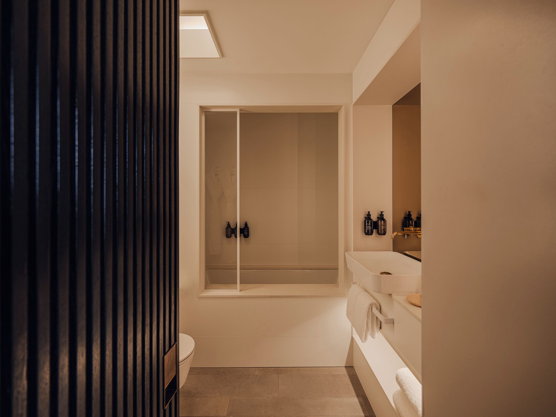 A modern bathroom with a bathtub, a toilet, and a sink.