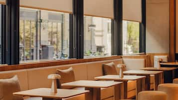 A modern interior with seating areas, tables, and large windows.