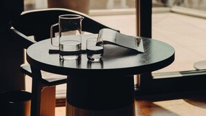 Un comedor moderno con una mesa redonda, una jarrón y dos vasos.