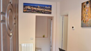 A room with a wooden floor, a desk with a laptop and a plant, a radiator, and a chair. - Florence Stadium B&B (Florence)