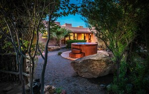 A courtyard with a hot tub, large rocks, and a building with a tiled roof. - Sierra Grande, A Ted Turner Retreat (Truth or Consequences)