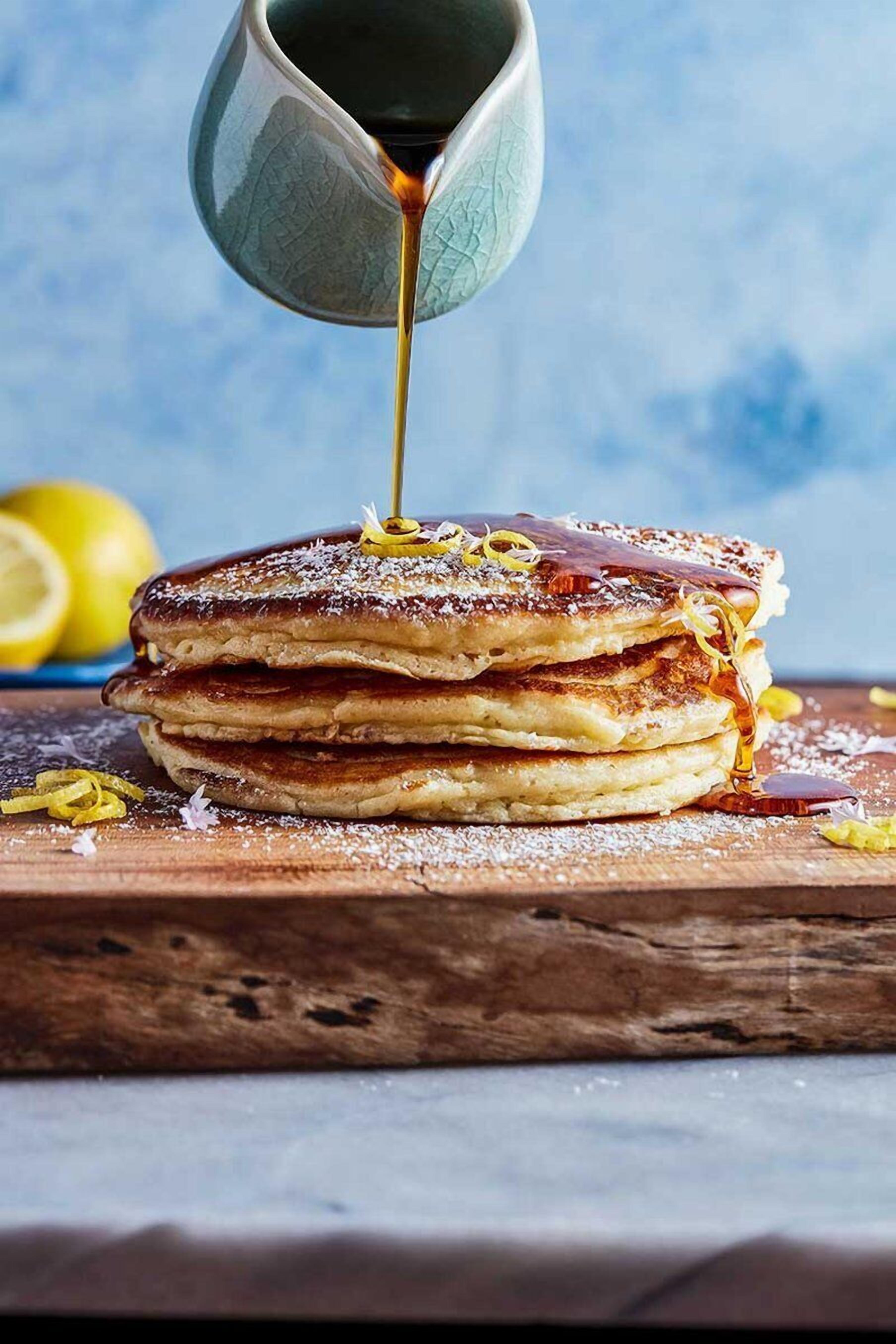 Une pile de crêpes arrosées de sirop.