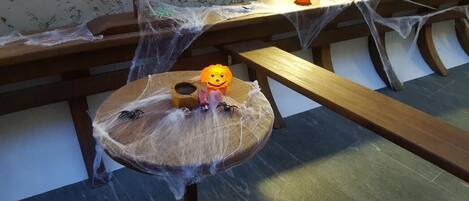 A dining table with a Halloween-themed decoration, including a pumpkin and spider web.