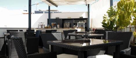 An outdoor dining area with wicker furniture and a covered section.