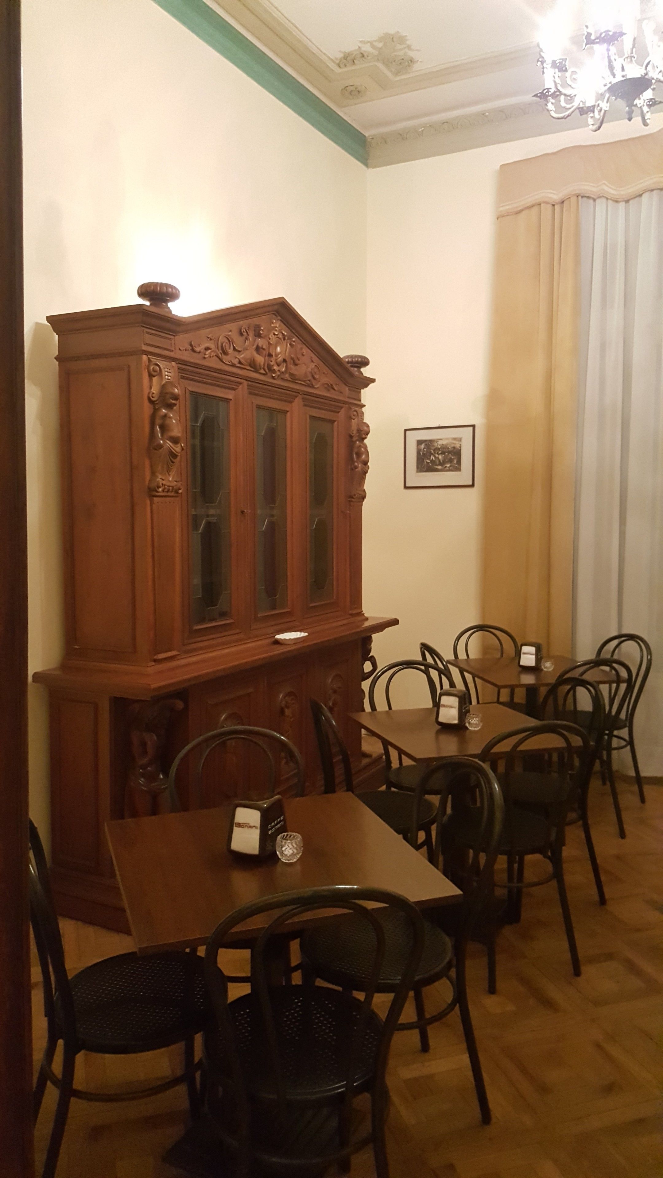 Un comedor con un aparador de madera, varias sillas y una mesa.